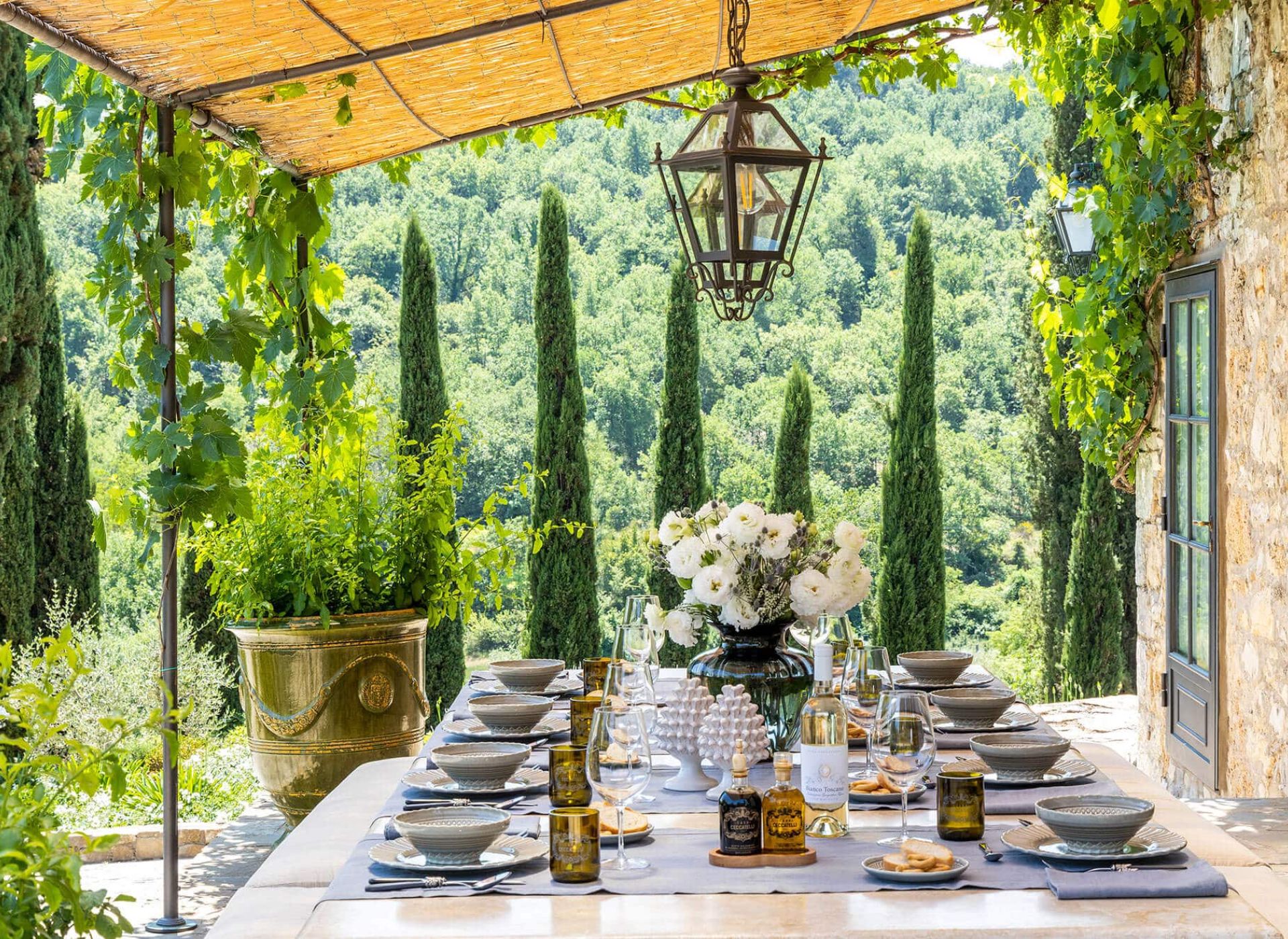 Stone farmhouse at Tenuta Ceccatelli surrounded by gardens and rolling Tuscan hills