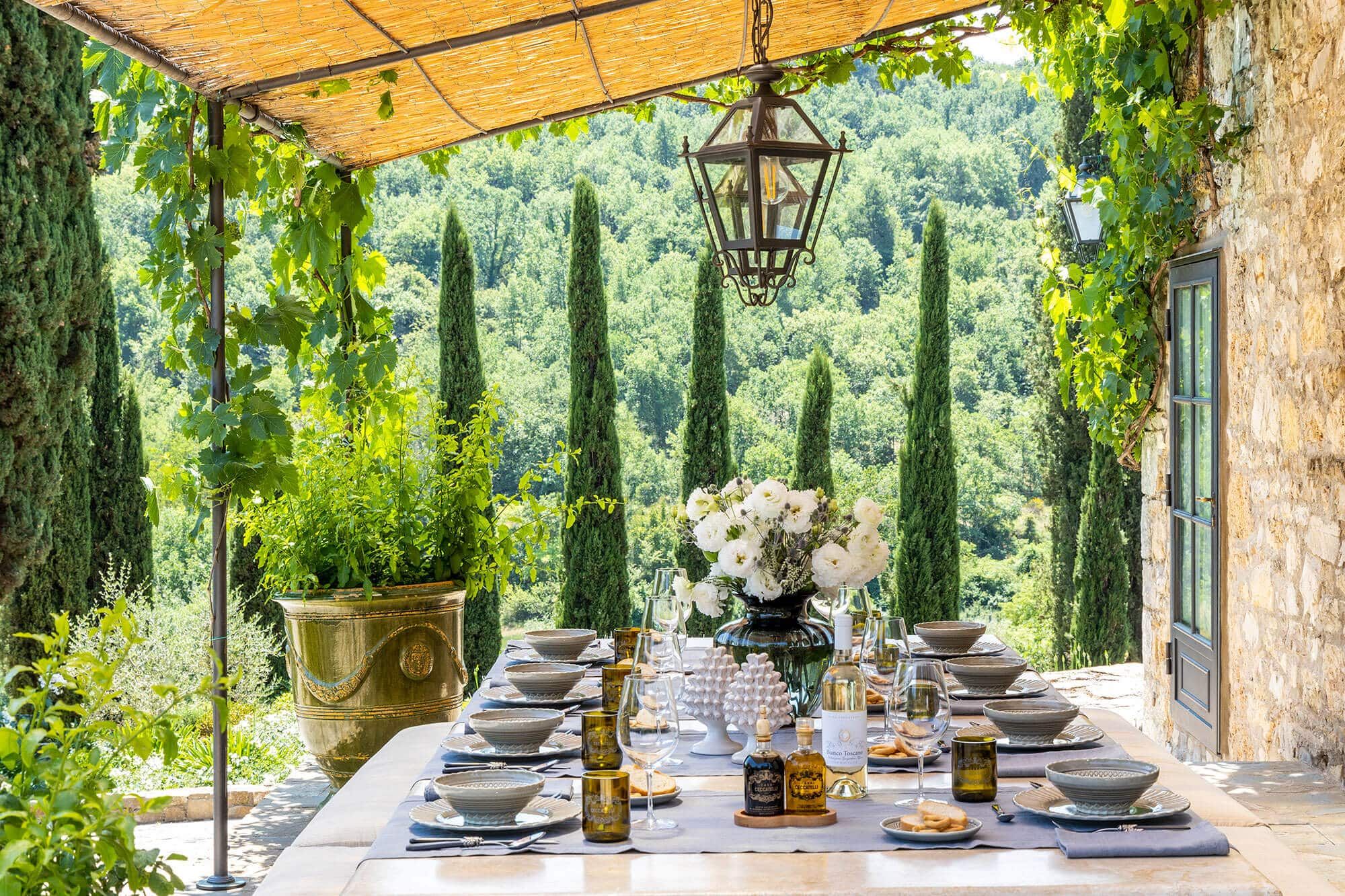 Al fresco dining terrace shaded by vines in the Tuscan countryside