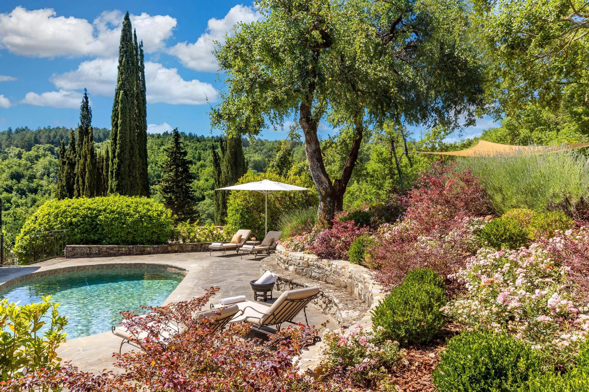 Swimming pool surrounded by gardens at a historic Tuscan estate