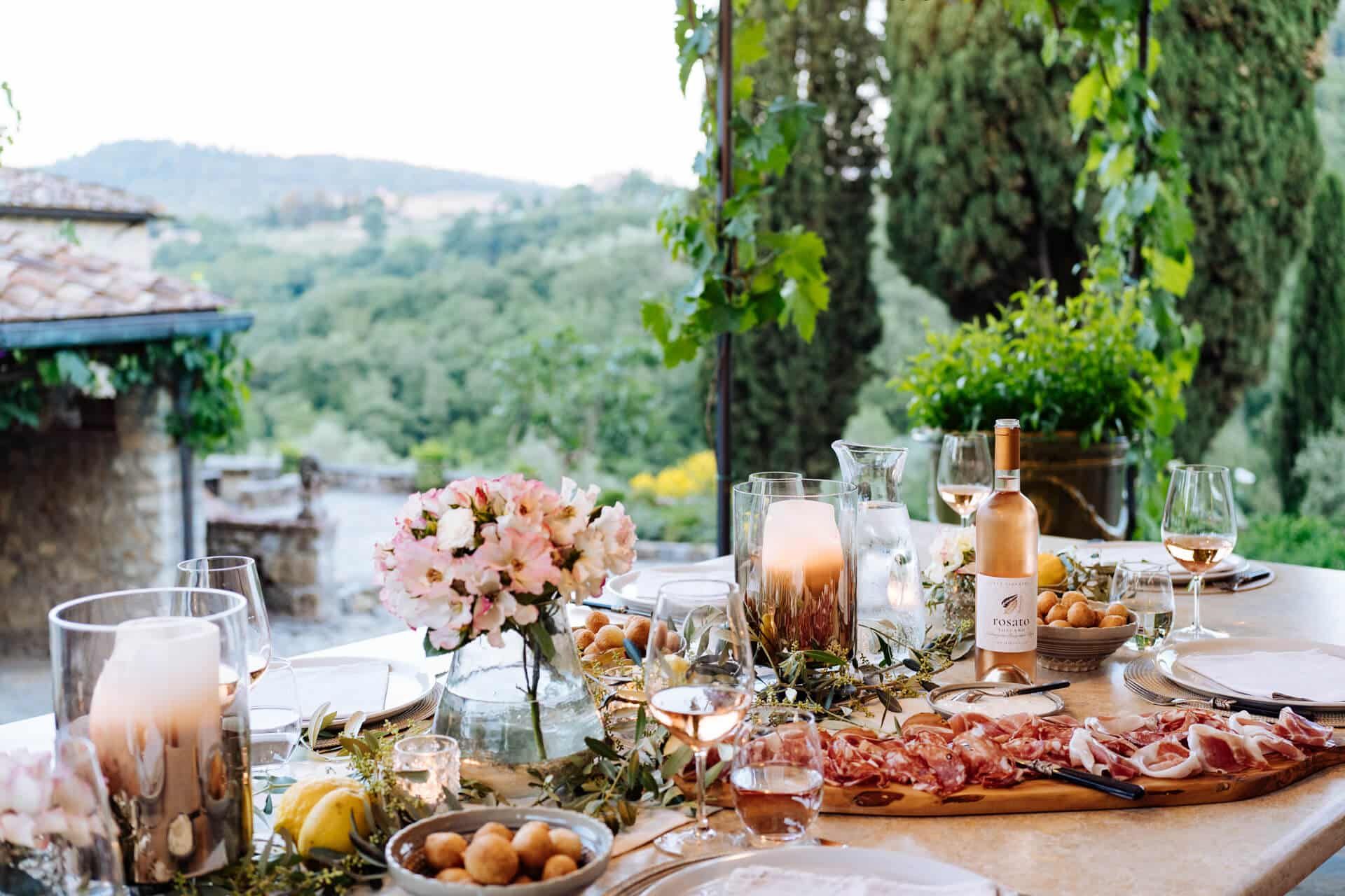 Outdoor dining table at Tenuta Ceccatelli set with local wine and Tuscan countryside views